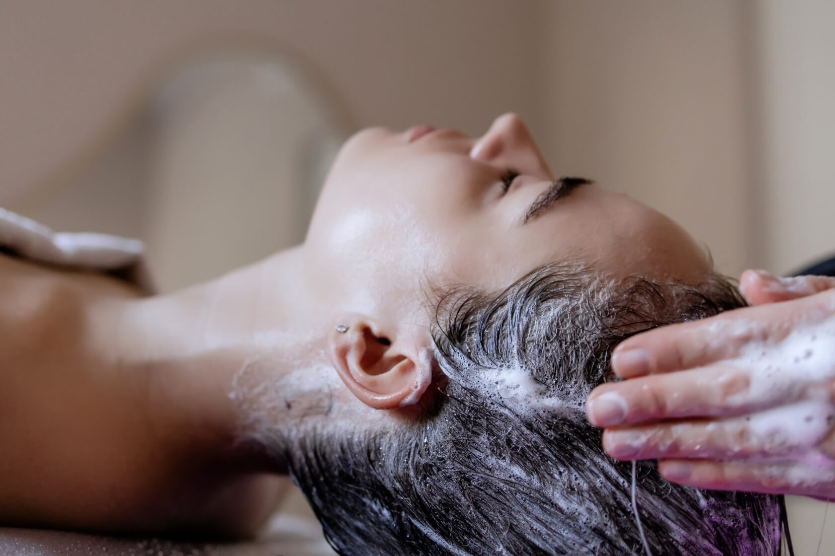 Client receiving a Vital Glow head spa scalp wash treatment with soothing foam massage for relaxation and scalp cleansing